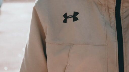 woman standing while wearing white Under Armour zip-up jacket