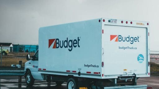 a blue and white budget truck parked in a parking lot