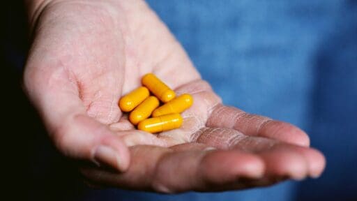 yellow thorne medication pills in persons hand