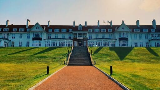 a large white building with a long walkway leading to it
