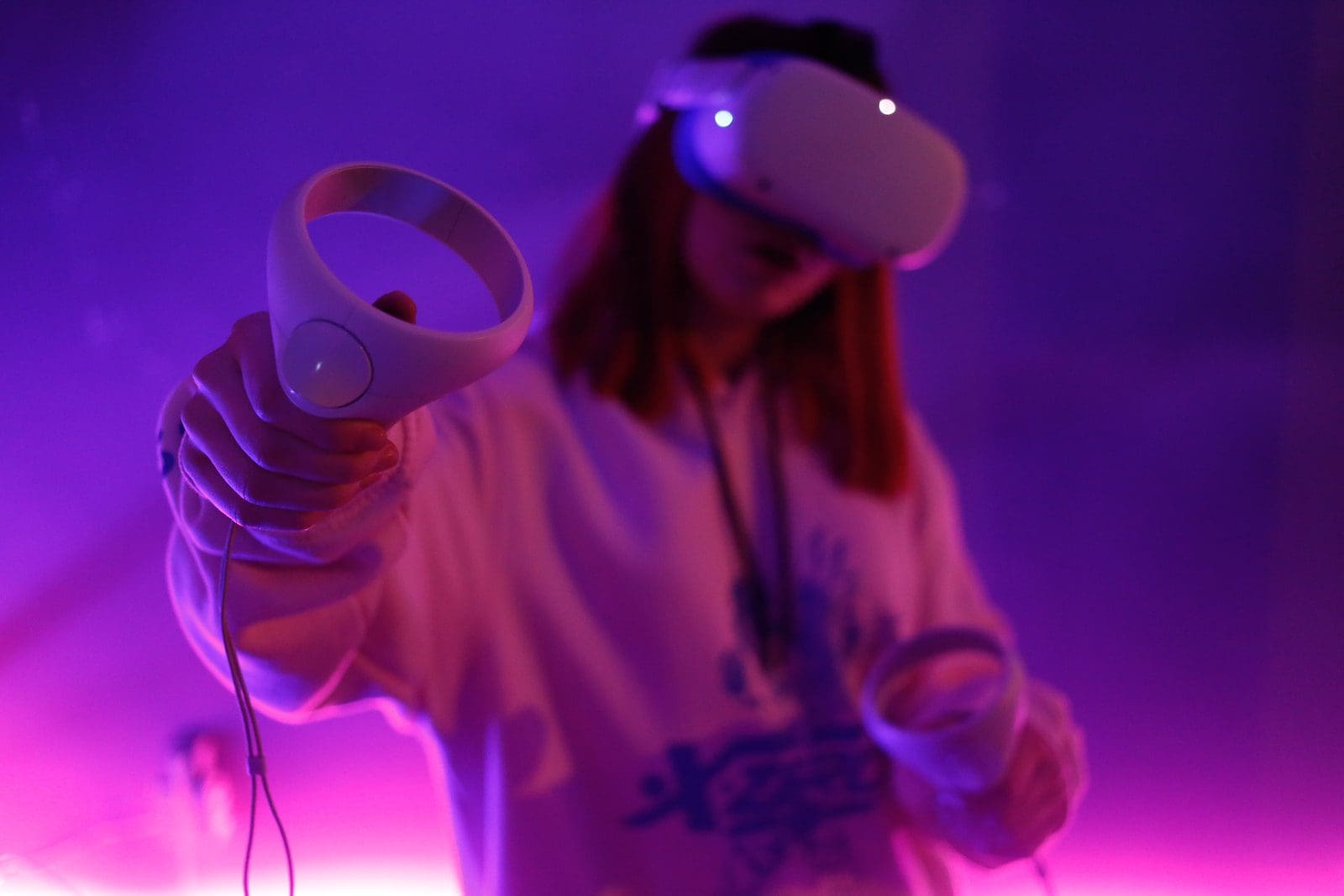 a woman holding a Oculus/ Meta quest controller in her hand