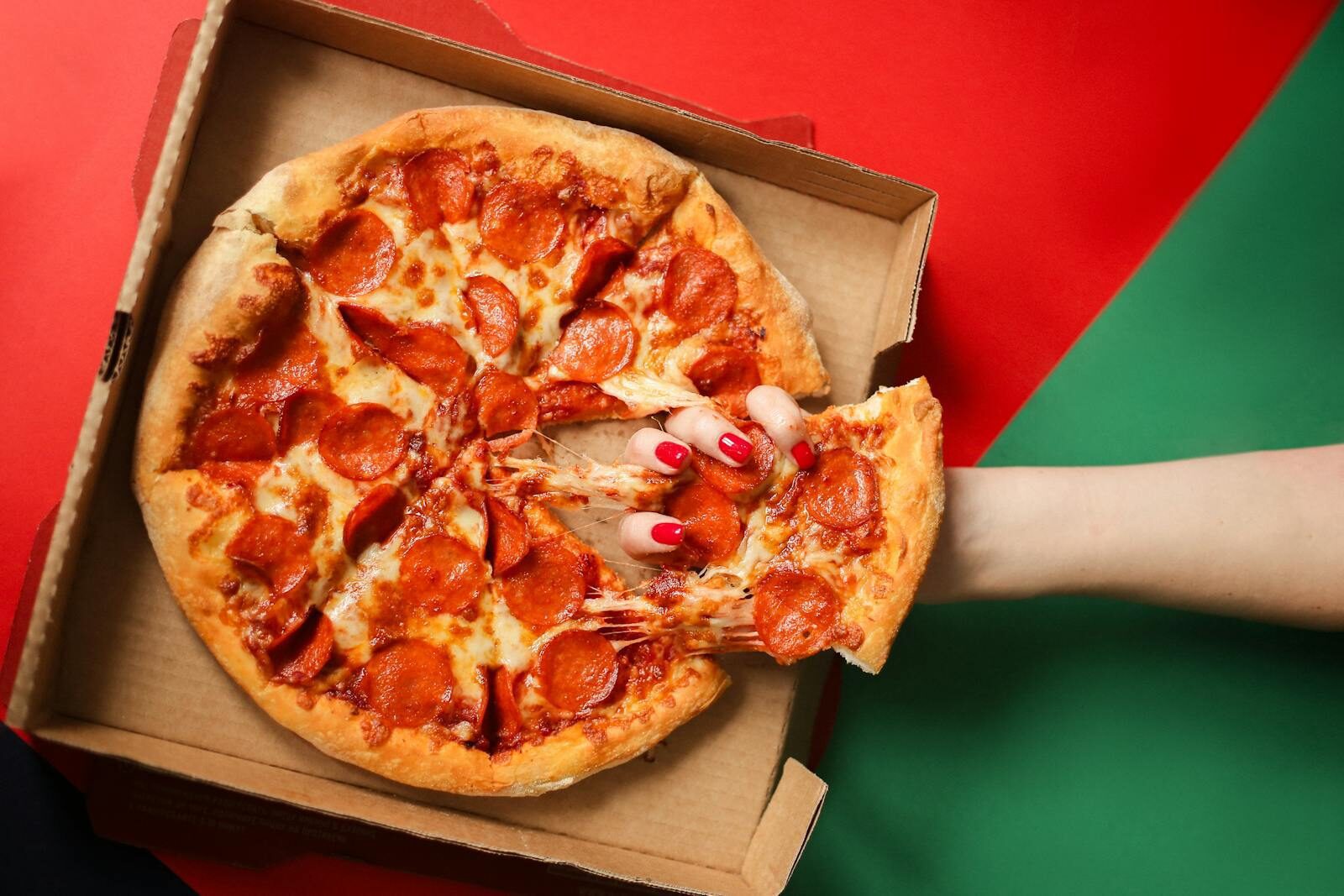 Fresh pizza being pulled from the box after using papa johns first responder discount