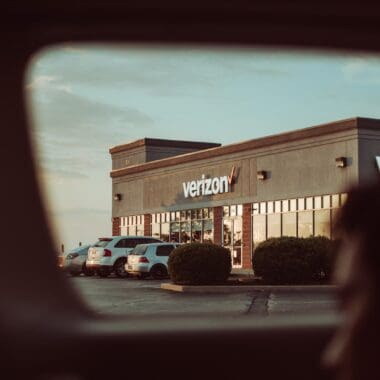 cars parked in front of Verizon store during daytime