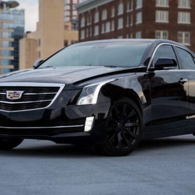 black cadillac parked on road during daytime