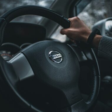 teacher holding black nissan steering wheel